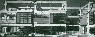 Schwarz-Weiß-Foto eines mehrstöckigen Stahlbeton-Gebäudekomplexes in München mit sichtbarer Skelettstruktur und Glasfassaden.