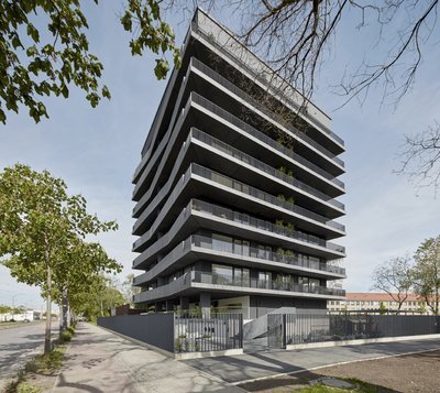 Modernes, dunkles Mehrfamilienhaus mit Balkonen an der Straße in Dresden.