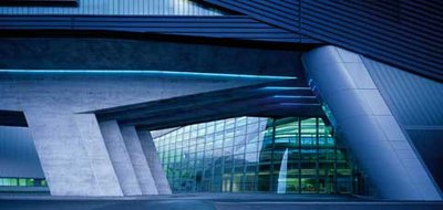 Architektonische Detailaufnahme des BMW-Werks in Leipzig mit markanten Betonstützen, Glasfassade und blauer Akzentbeleuchtung.